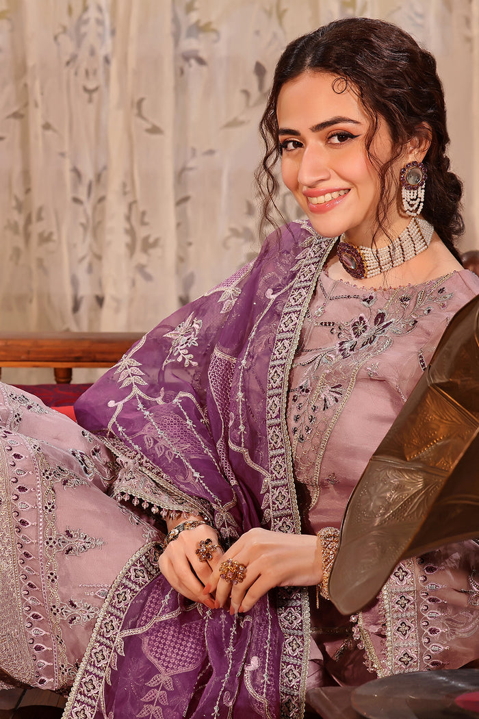 Smiling seated pose of NAQSHI Abeer outfit showing polished ready-to-wear finish and detailed embroidery work