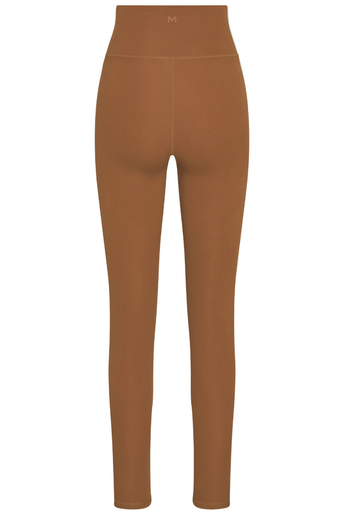 Back view of Acadia Legging in Caramel showing high waist, center back seam, and small embossed M logo on a white background