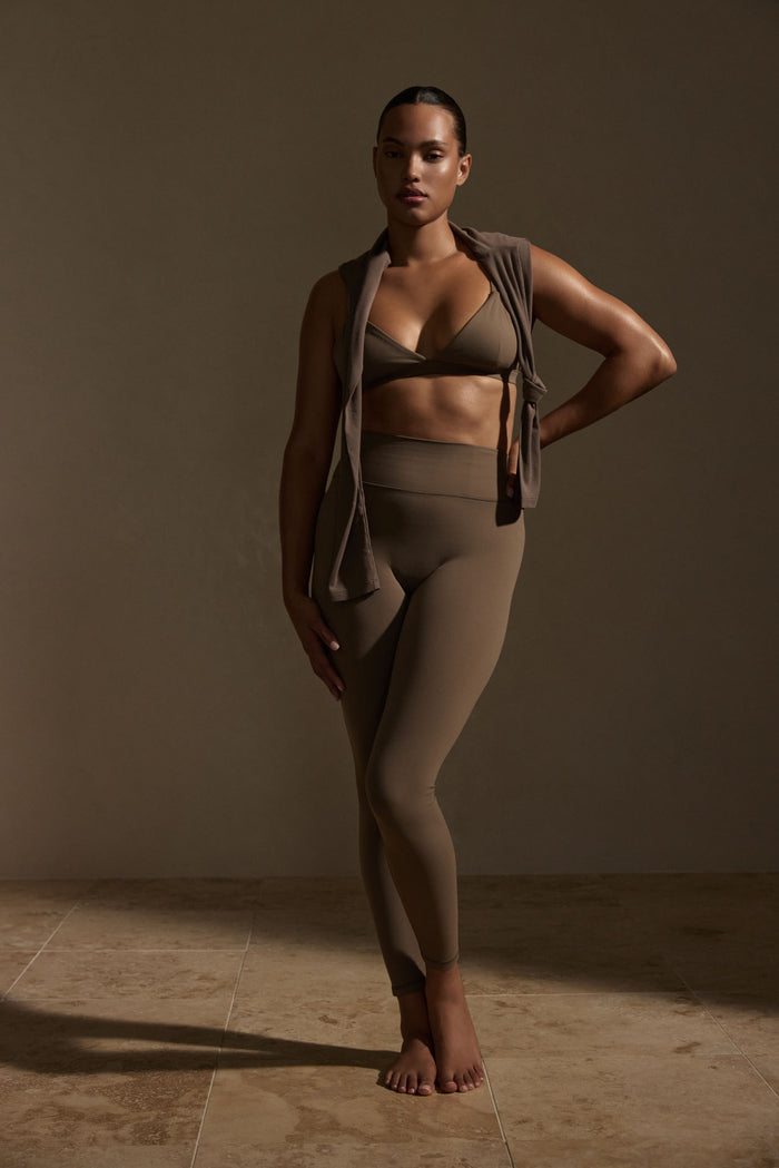 Front view of Acadia legging in stone showing high-rise waistband and full-length slim fit on model, neutral backdrop