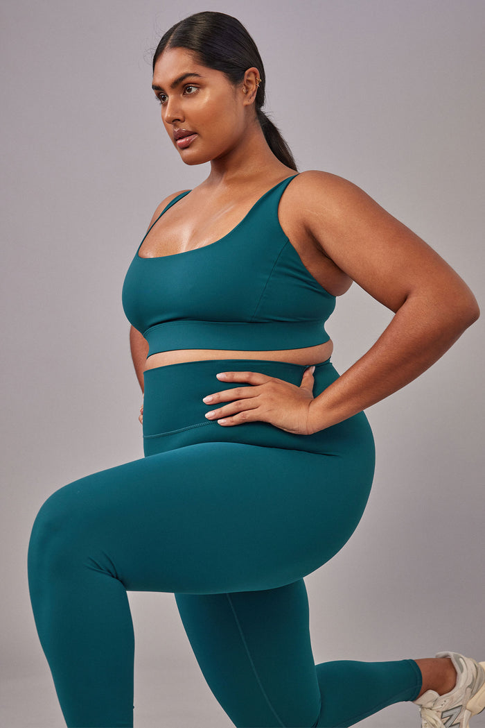 Side view of Acadia Legging 27-inch in Evergreen on plus-size model, showing high-rise waistband and smooth sculpting fabric