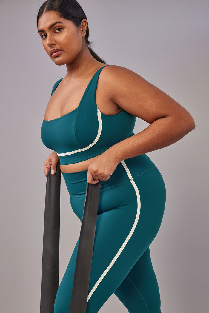 Side view of Acadia Legging 27-inch in Evergreen/Ivory showing high-rise waistband and ivory contrast side stripe on model