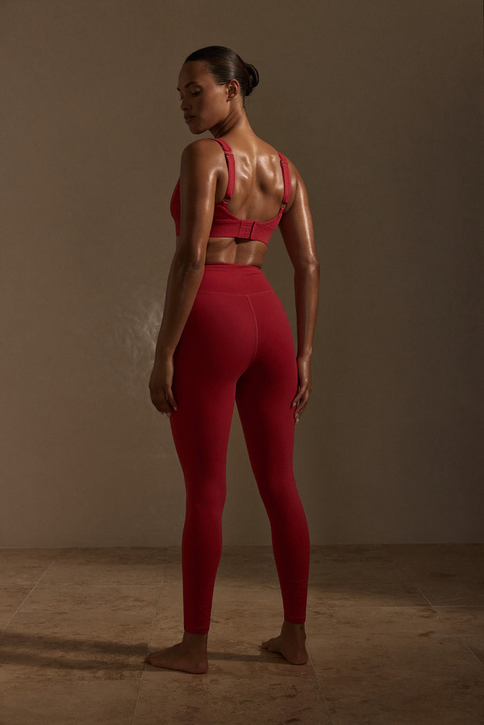 Rear view of Acadia Legging Long in Cherry on model showcasing high waist and contoured back seam on neutral studio background
