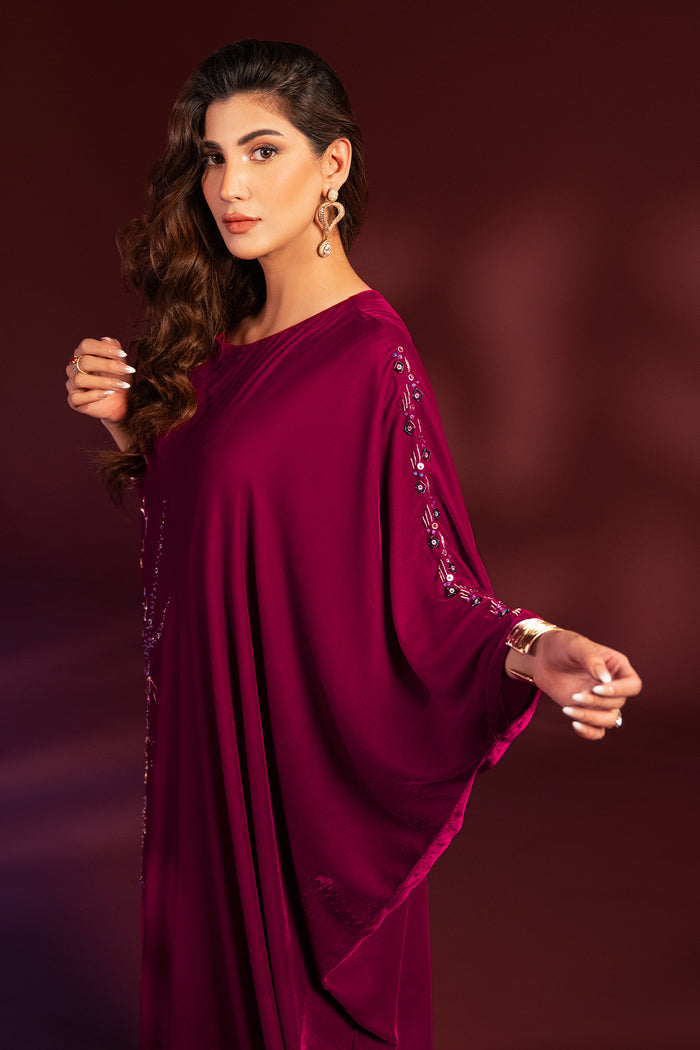 Side angle view of NAQSHI Aelin shocking pink kaftan tunic highlighting fitted sleeve with cuff embellishment