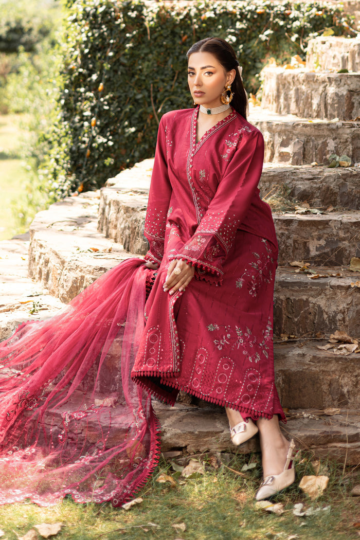 Seated front view of NAQSHI garnet red outfit showing embroidered hem and detailed neckline
