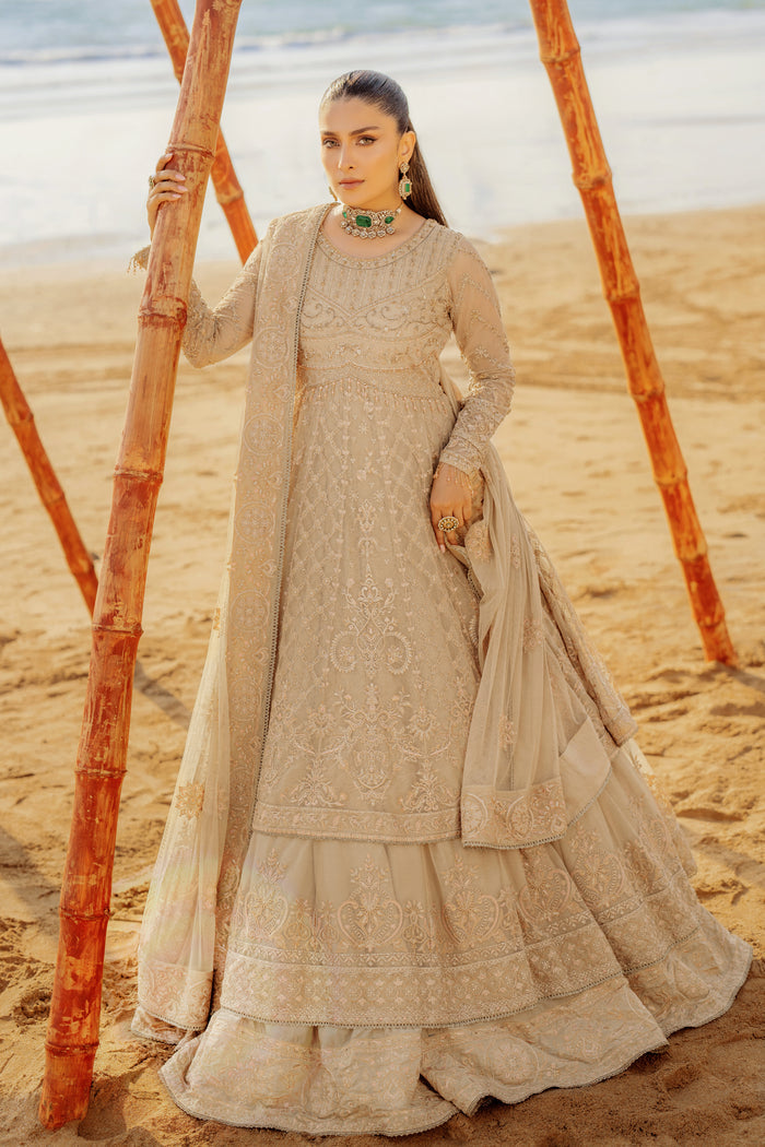 Side profile of NAQSHI Alara showcasing flowing floor-length cutline, layered tiers with embroidered sequin borders, hand‑embroidered sleeves and handmade hanging tassels visible.