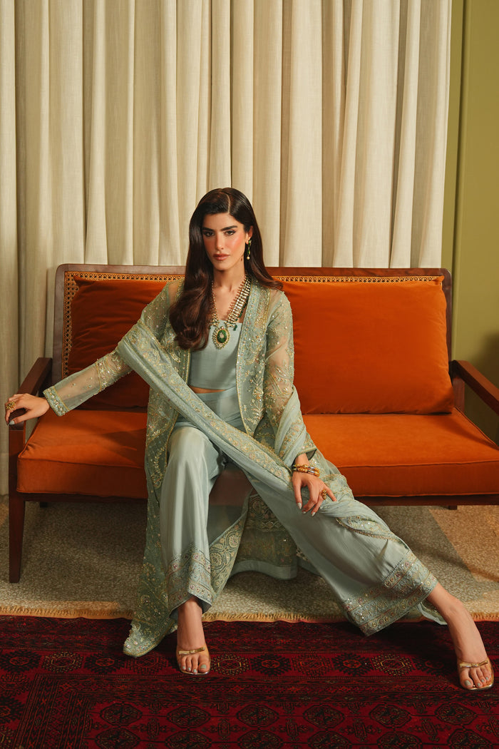 Seated full view of NAQSHI Alyana dusty blue ready-to-wear outfit showing culottes, flowing gown, and balanced formal shape.