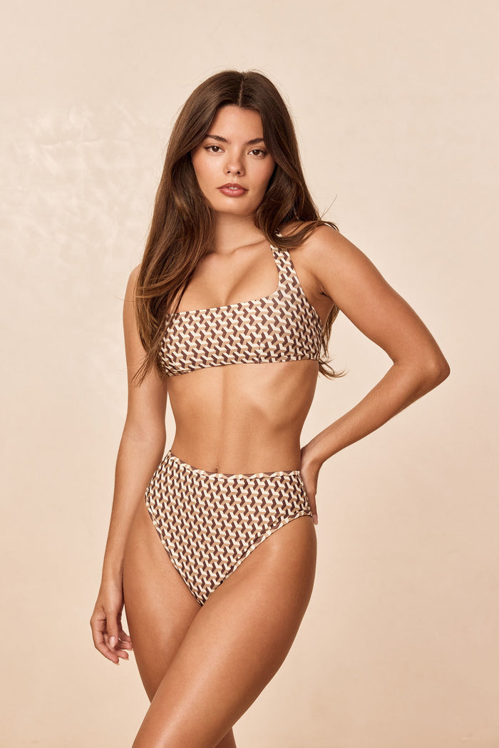 Front view of Amalfi Top in Husk Geo showing square neckline and adjustable halter strap on model against beige backdrop