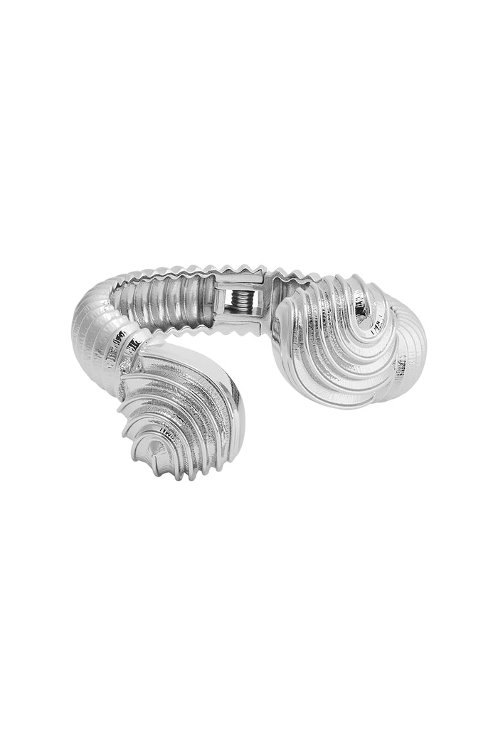 Top close-up of Antigua Cuff in silver showcasing ribbed, shell-shaped ends and visible spring-hinge clasp on a white background