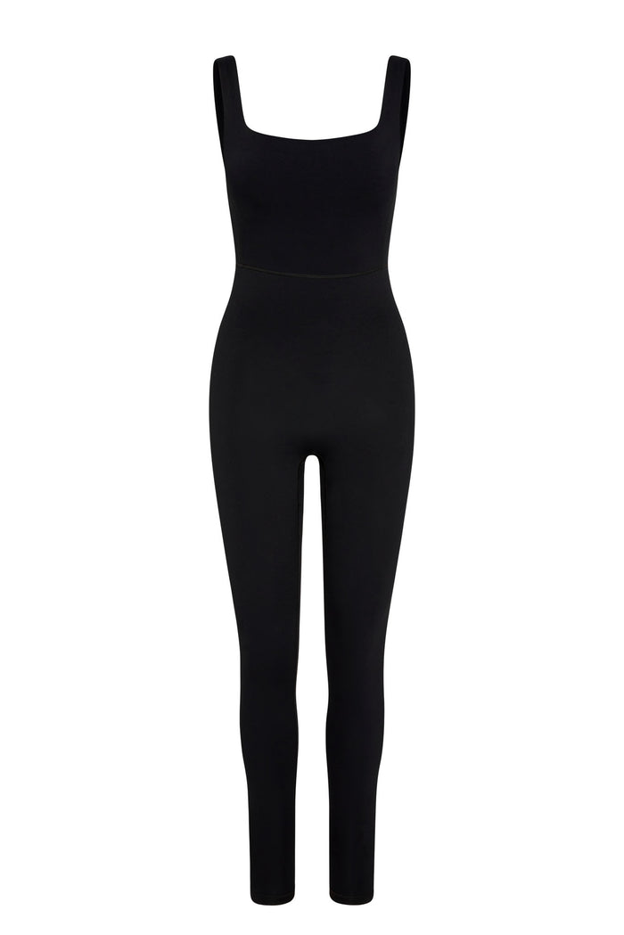 Front view of Aspen Catsuit in black jersey showcasing square neckline, high waist seam and full-length tapered legs on white background