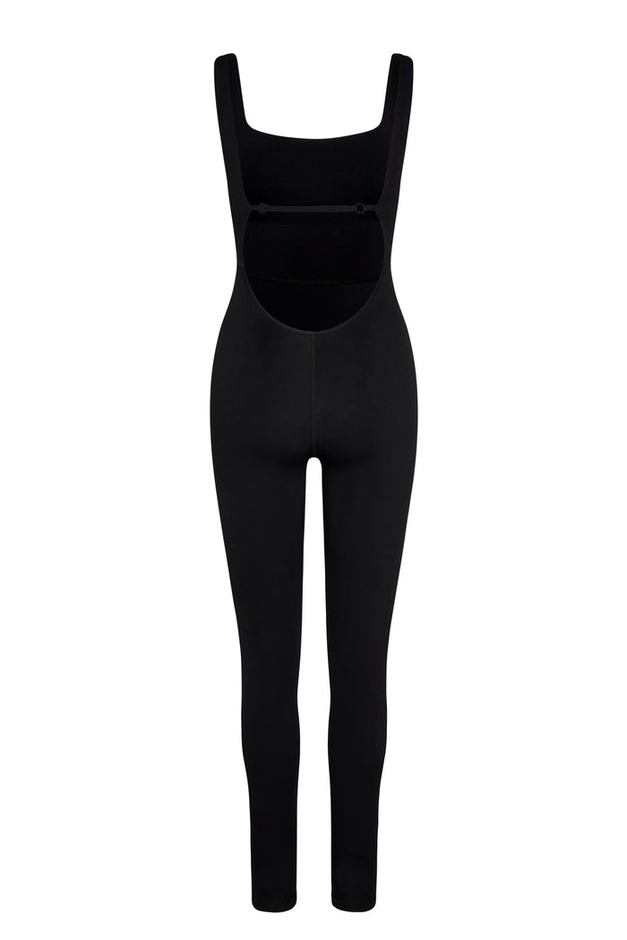 Back view of Aspen Catsuit in black jersey showing low open back with adjustable strap and full-length fitted legs on white
