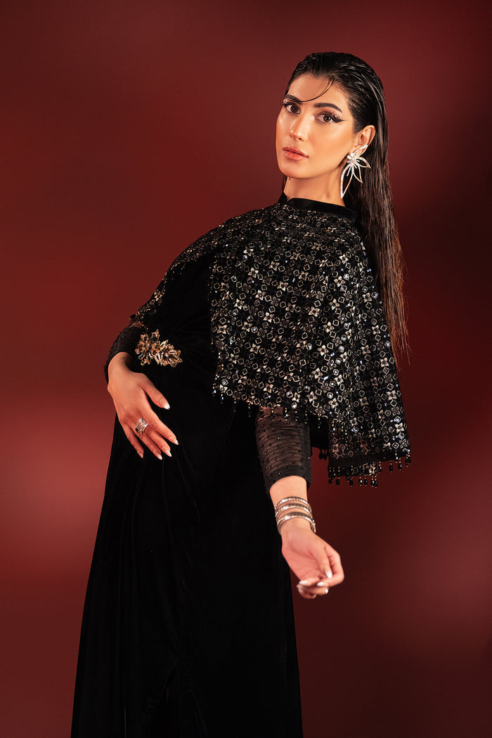 Three quarter pose of Ayna black formal dress showing fitted net sleeves and waist brooch detail, polished ready made dinner wear.