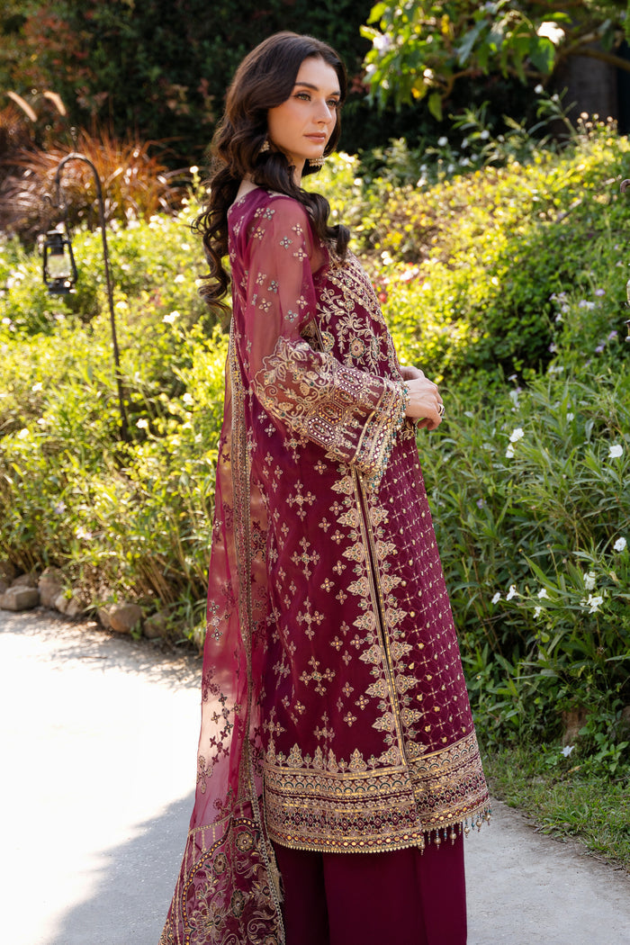 Side view of NAQSHI Azra maroon organza outfit highlighting side slits with embroidery, sequin details, and flowing dupatta styling.