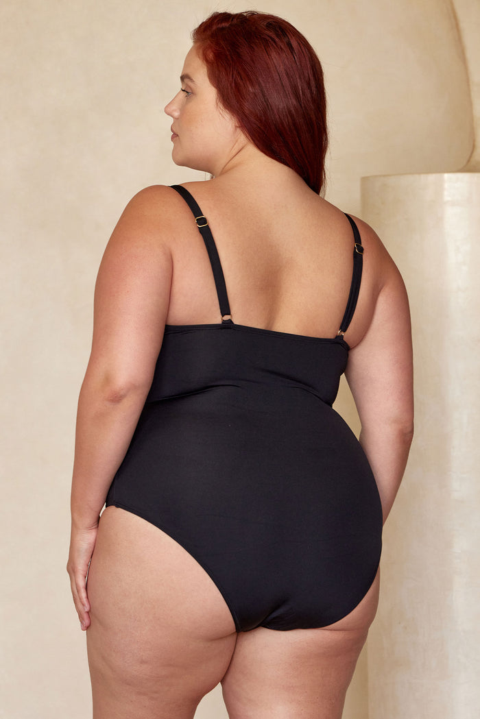Back view of Bahamas One Piece black swimsuit on plus-size model, adjustable straps and moderate rear coverage