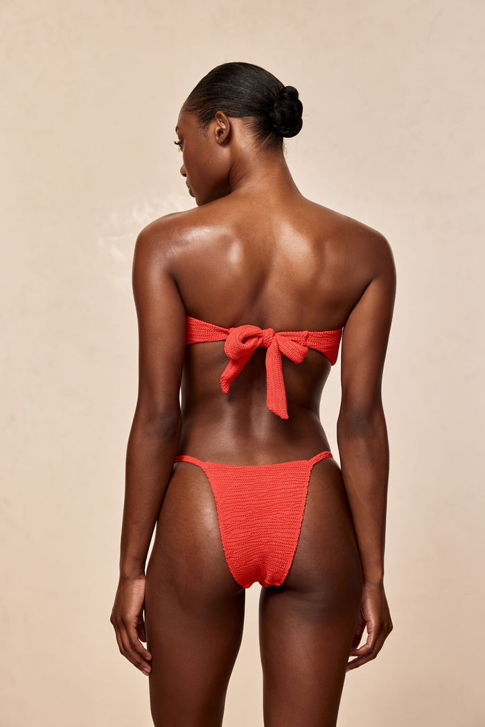 Back view of Barbados Bottom in Chili Pepper Crinkle showing minimal coverage and thin side straps on beige background