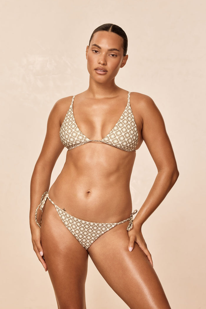 Front view of Barbados top in Tile Geo print, triangle bikini top with thin adjustable straps on a beige background