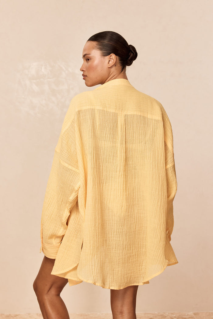 Back view of Barcelona Tunic in Honey Crinkle showing crinkled texture and oversized fit on model against neutral background