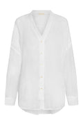 Front view of Barcelona Tunic in white linen showcasing V-neck, button front with mother-of-pearl buttons and long sleeves on white background