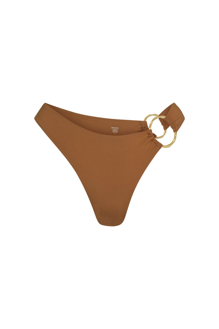 Front view of Bari Bottom in caramel showing high-cut mid-rise cheeky fit and gold double-ring side detail on white