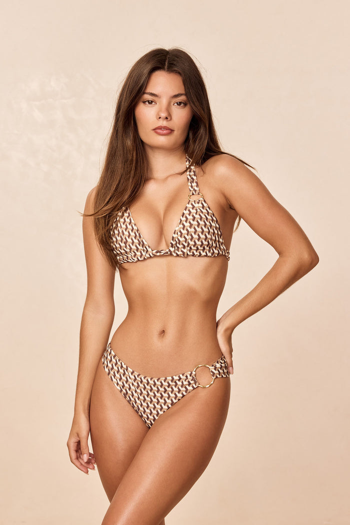 Front view of Bari Bottom Husk Geo showing mid-rise bikini with brown geometric print and gold hip ring on beige background