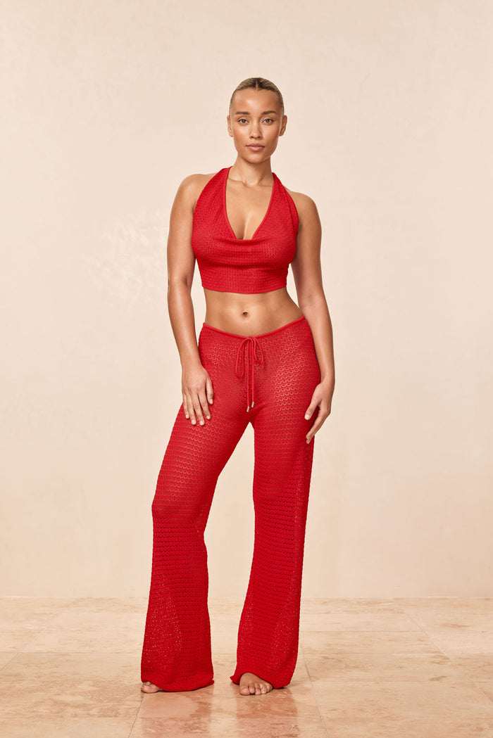 Front view of Belize Knit Pant in Chili Pepper lace crochet on model showing sheer open-knit fabric, drawstring waist, and flared legs on a neutral studio background