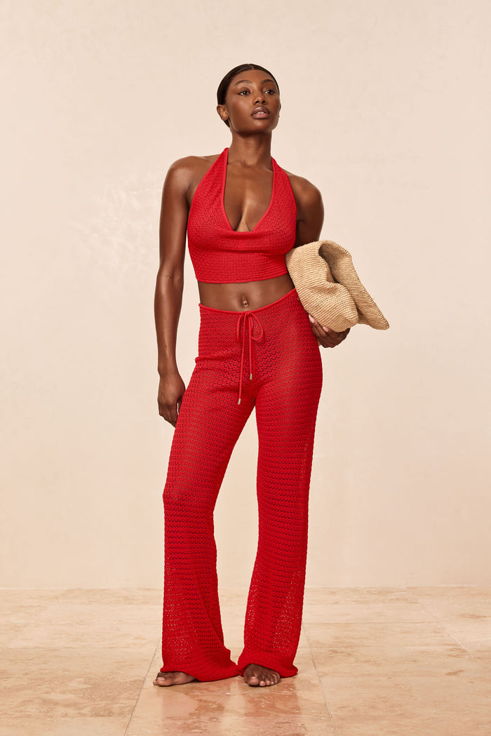 Three-quarter view of Belize Knit Pant in Chili Pepper showing sheer open-knit fabric and adjustable drawstring waist on model