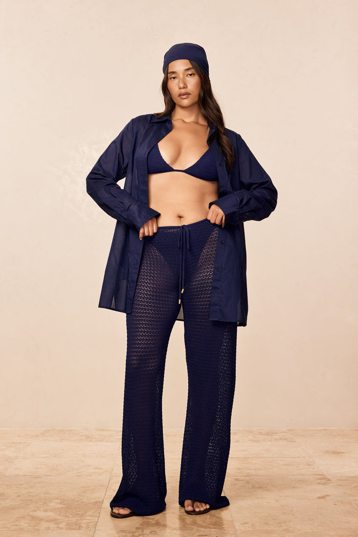 Full-length front view of Belize Knit Pant in Midnight showing crochet knit pattern, drawstring waist and relaxed fit on model with beige background