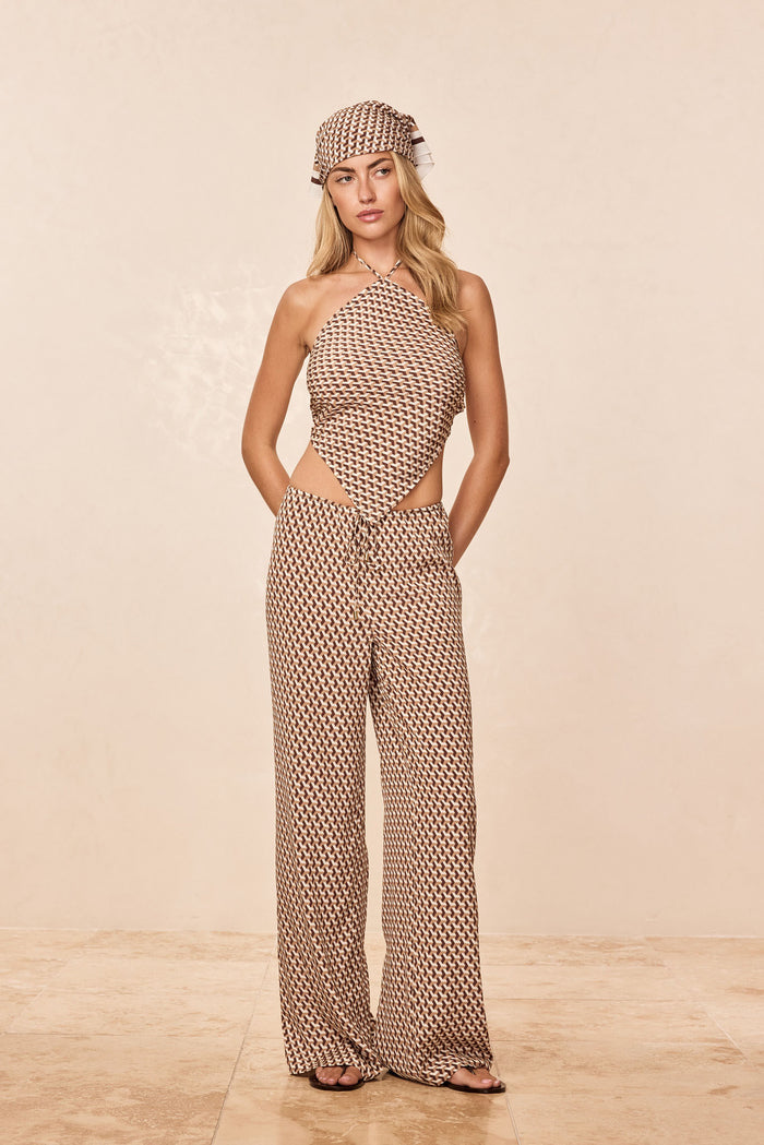 Full length front view of Belize Pant Husk Geo Silk showing brown geometric pattern, wide-leg relaxed fit and drawstring waist on model against a beige backdrop