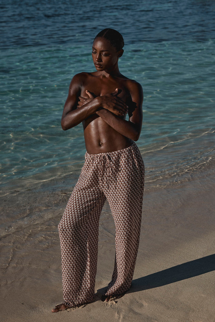 Full-length front view of Belize Pant in Husk Geo print showcasing wide-leg linen fabric and adjustable drawstring waist on model at the shoreline