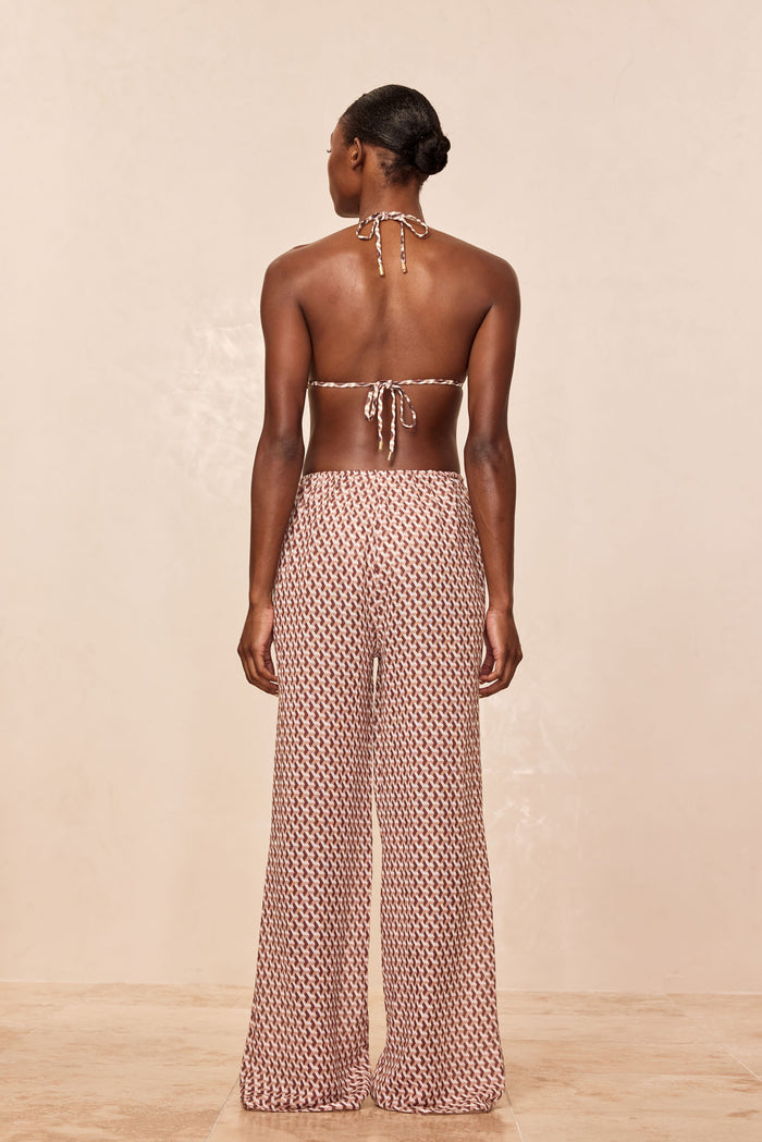 Back view of Belize Pant in Husk Geo showcasing high-waist wide-leg silhouette and elastic drawstring waist on beige backdrop
