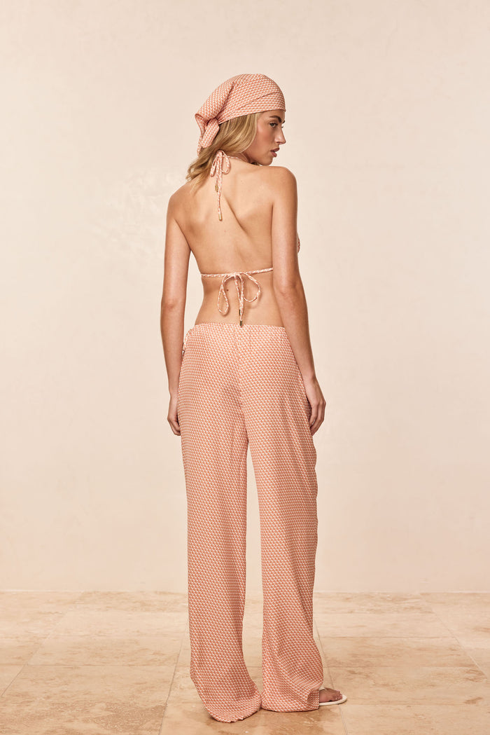 Rear view of Belize pant in peach micro geo silk showcasing wide leg relaxed fit on model with neutral beige background