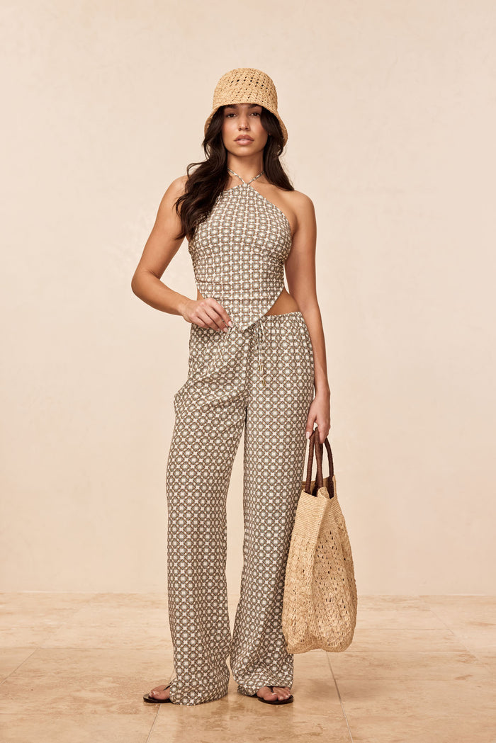 Front view of Belize Pant in Tile Geo Silk with geometric print, drawstring waist and wide-leg fit on beige background