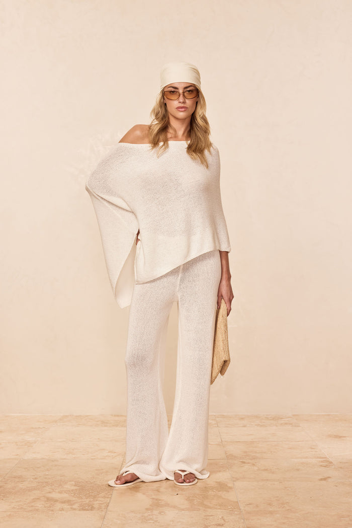 Front of Belize Pant Open Knit in Ivory on model, sheer open-knit wide-leg with adjustable drawstring waist, beige backdrop