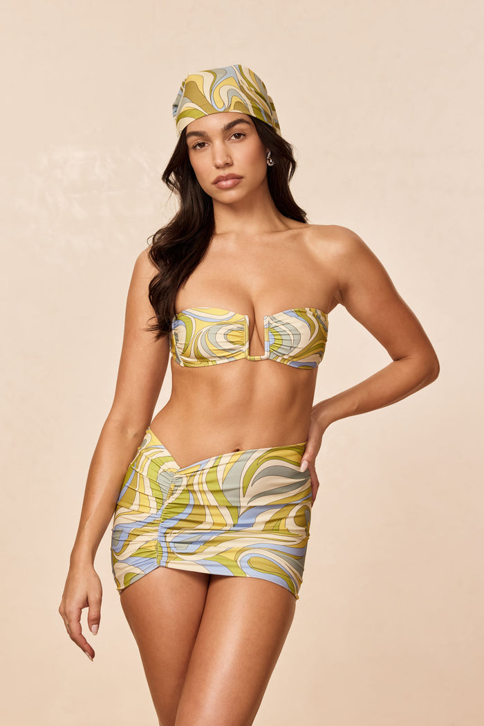 Front view of Bimini Skirt in Costa Rei Apple print showcasing ruched V-front mini silhouette on model with beige studio background