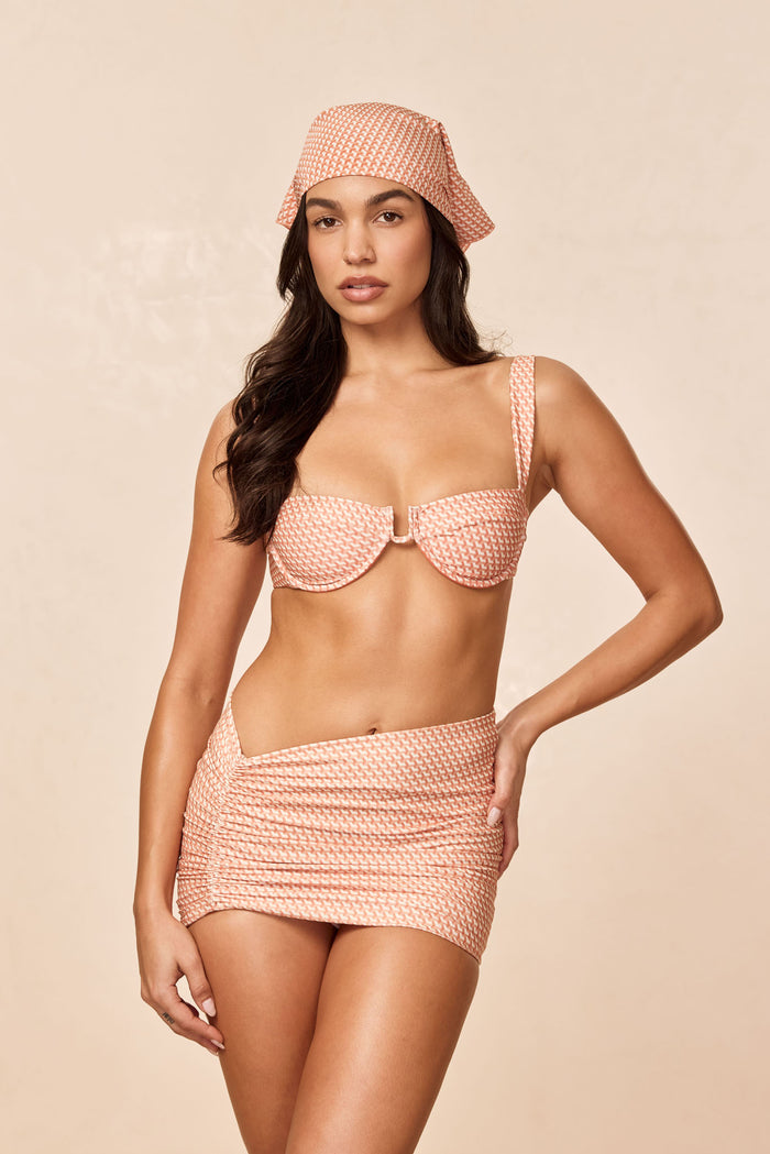 Front view of Bimini Skirt - Micro Geo showcasing ruched mini fit and matching print on model against beige background