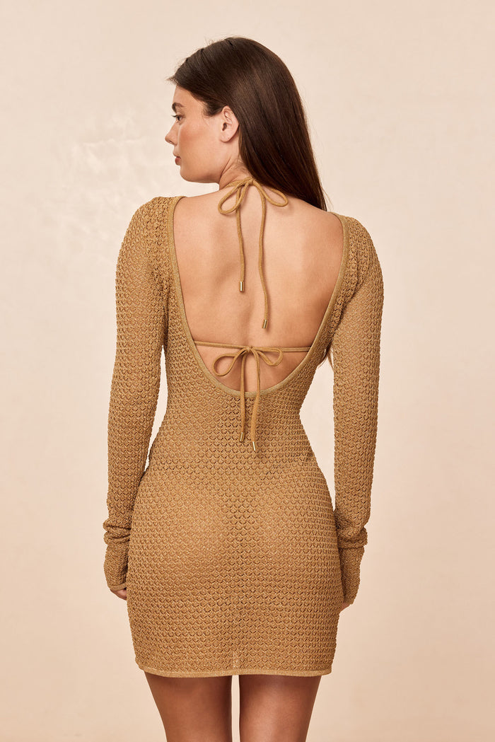 Rear view of Bodrum Mini Dress in antique gold lurex crochet showing scooped open back with tied straps on beige background