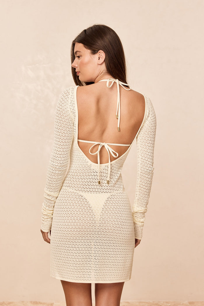 Back view of Bodrum Mini Dress with low open back, halter and waist ties, sheer ivory lace crochet on cream background