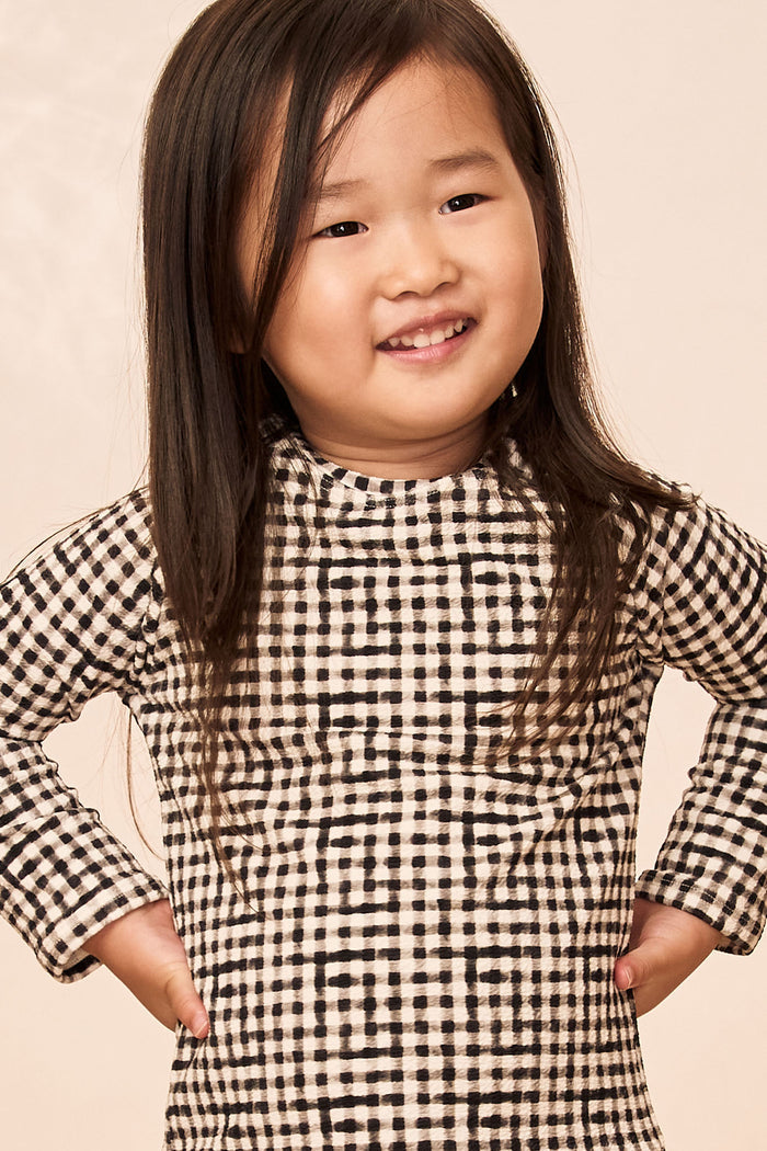 Front view of Bondi Rashguard Kids Black Gingham showcasing long-sleeve mock-neck rashguard on child model with pale beige background