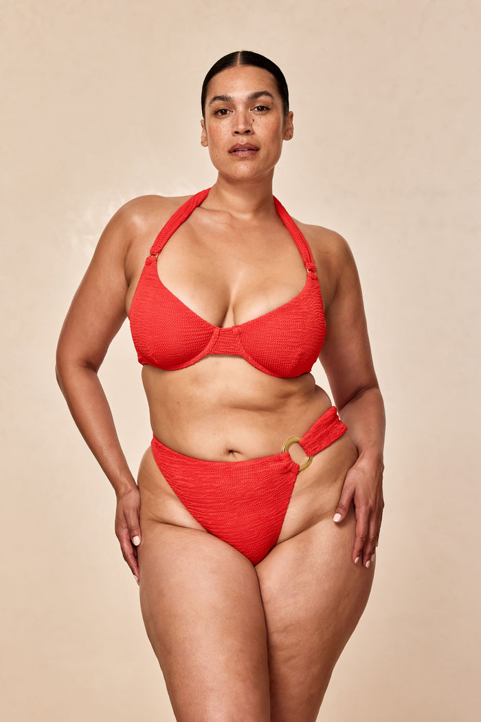 Front view of Honolulu Top in Chili Pepper Crinkle showing crinkle texture, underwire cups and knotted halter straps on model against beige background