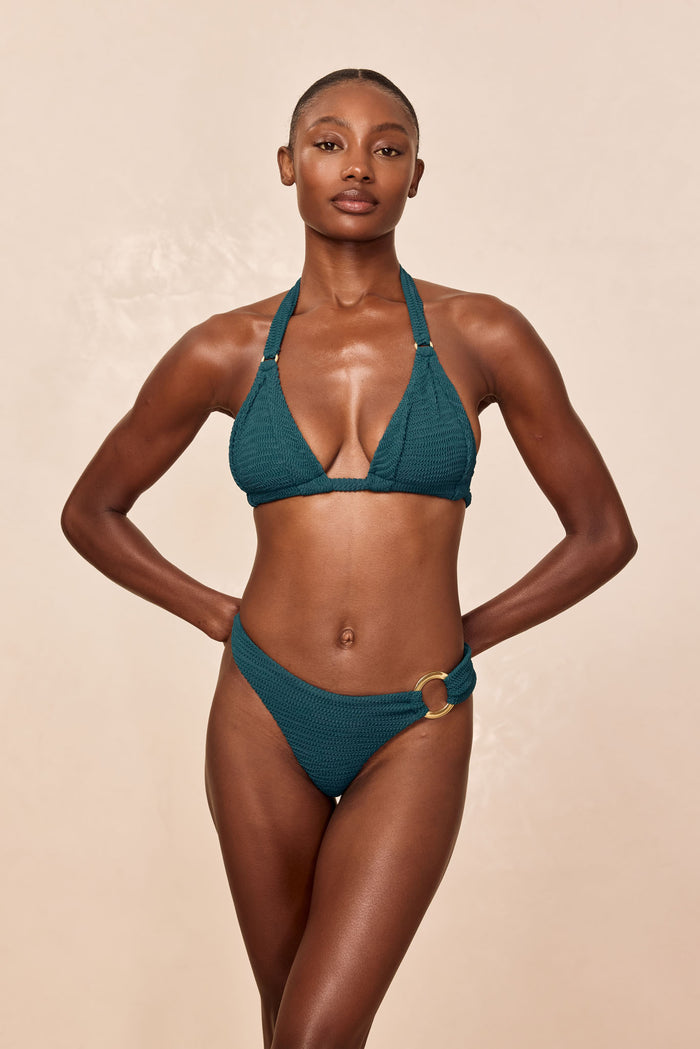 Front view of Bronte Bottom in Evergreen Crinkle with gold side ring, high-cut on model, beige background