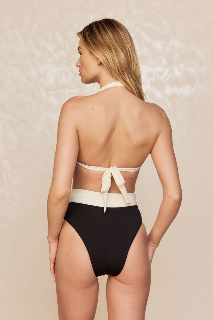 Back view of Bronte Top in black and ivory showcasing cream halter neck and knotted tie-back with neutral studio background