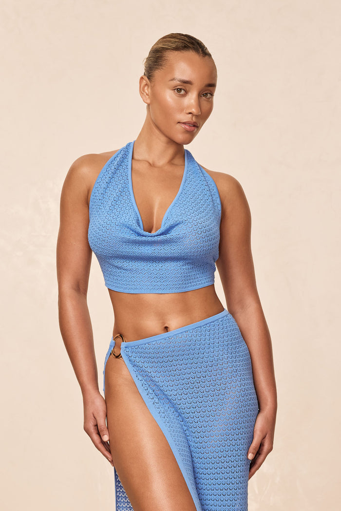 Front view of Bula cowl neck top, Azure Lace Crochet, draped cowl neckline and crochet texture on model, beige background