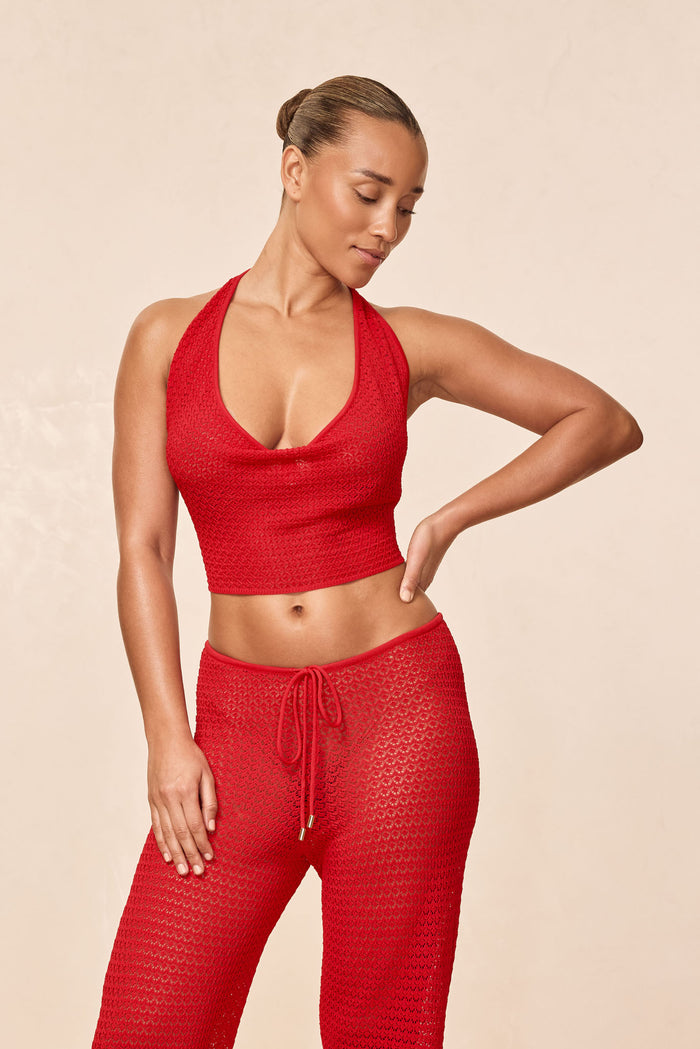 Three-quarter front of Bula cowl neck top in chili pepper red, showing cowl neckline, crochet lace texture and cropped fit on model