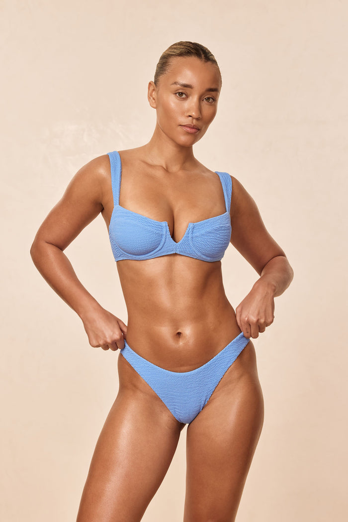 Front view of Byron Bottom in Azure Crinkle on model, textured fabric, high-cut leg, beige background