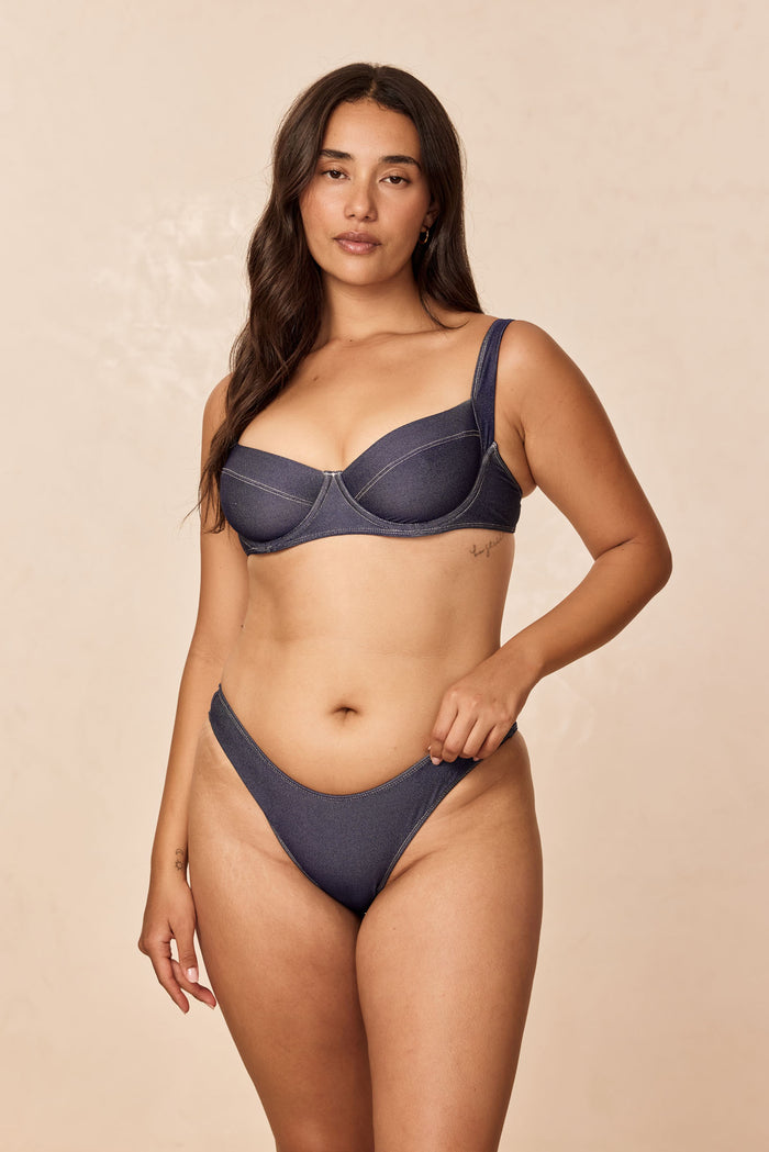 Front view of Sorrento Top in blue denim on model with underwire balconette cups and contrast stitching, beige background