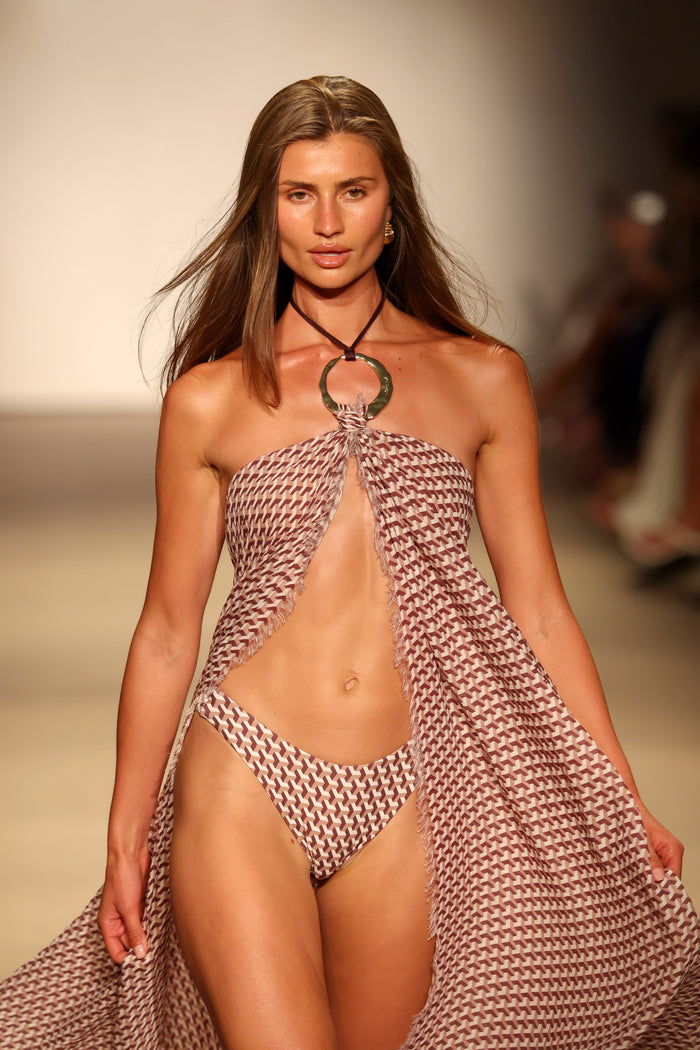 Front close-up of Byron Bottom Husk Geo on model showcasing mid-rise fit and cheeky coverage with neutral runway background