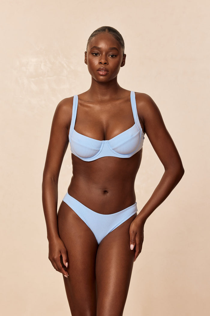Front view of Byron Bottom in Sky Rib on model showcasing mid-rise cut and ribbed texture against a beige studio background