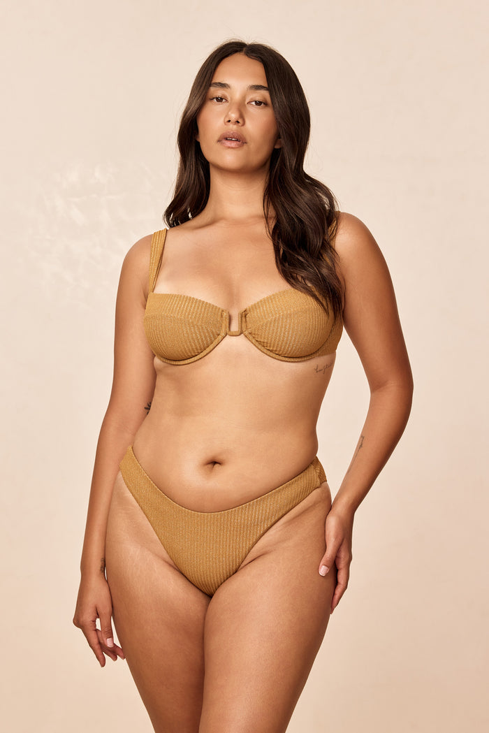 Front view of Cala Roja Top in antique gold lurex rib with underwire balconette cups and ribbed fabric on model