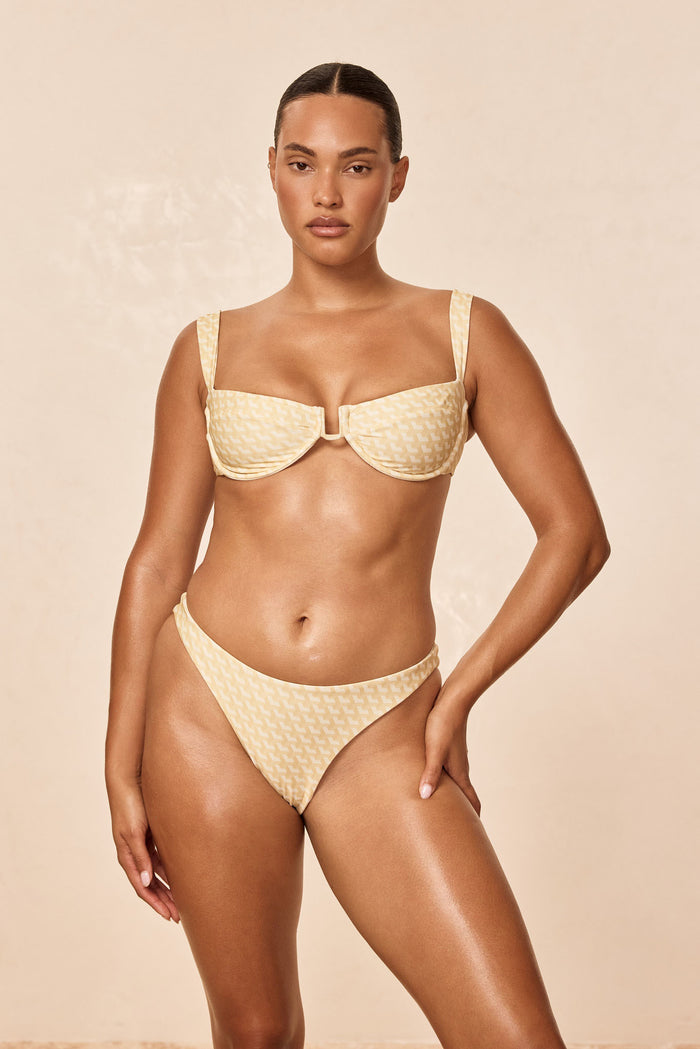 Front view of Cala Roja Top in Ivory Geo showing underwire U-wire cups and adjustable back tie on beige background