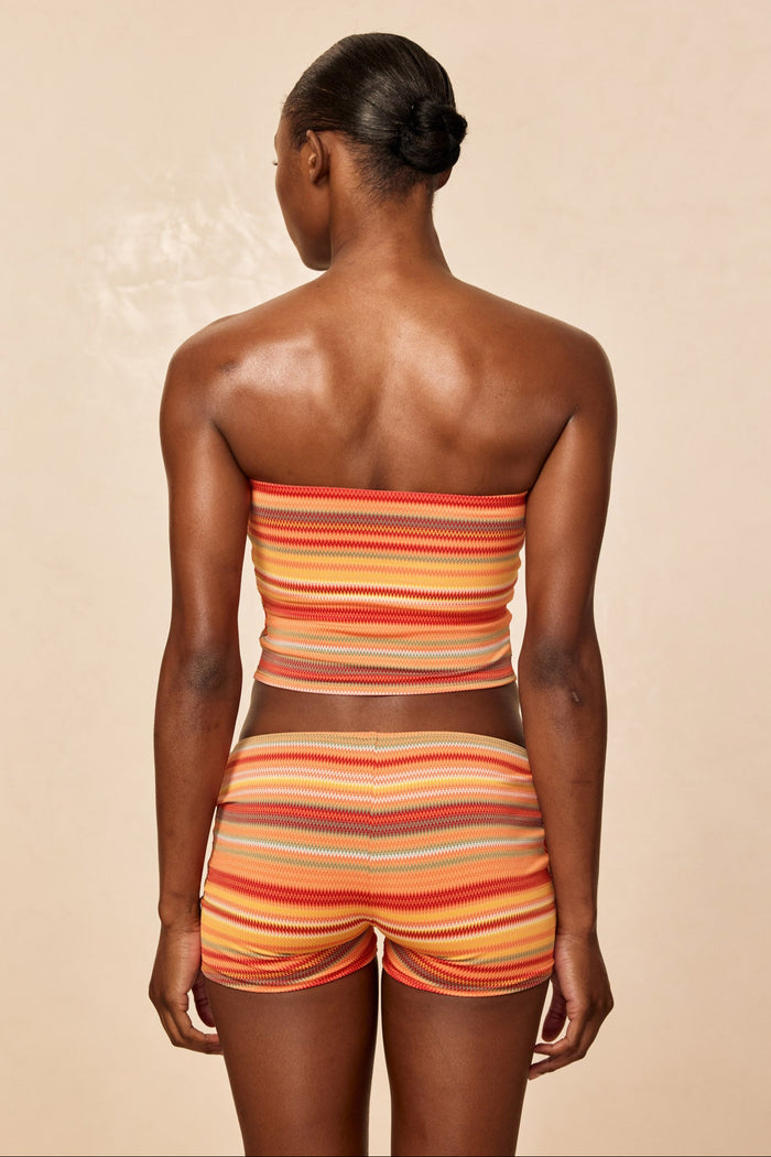 Back view of Laguna Top in Sardinia Stripe showcasing strapless tube silhouette on model with matching shorts against a beige background