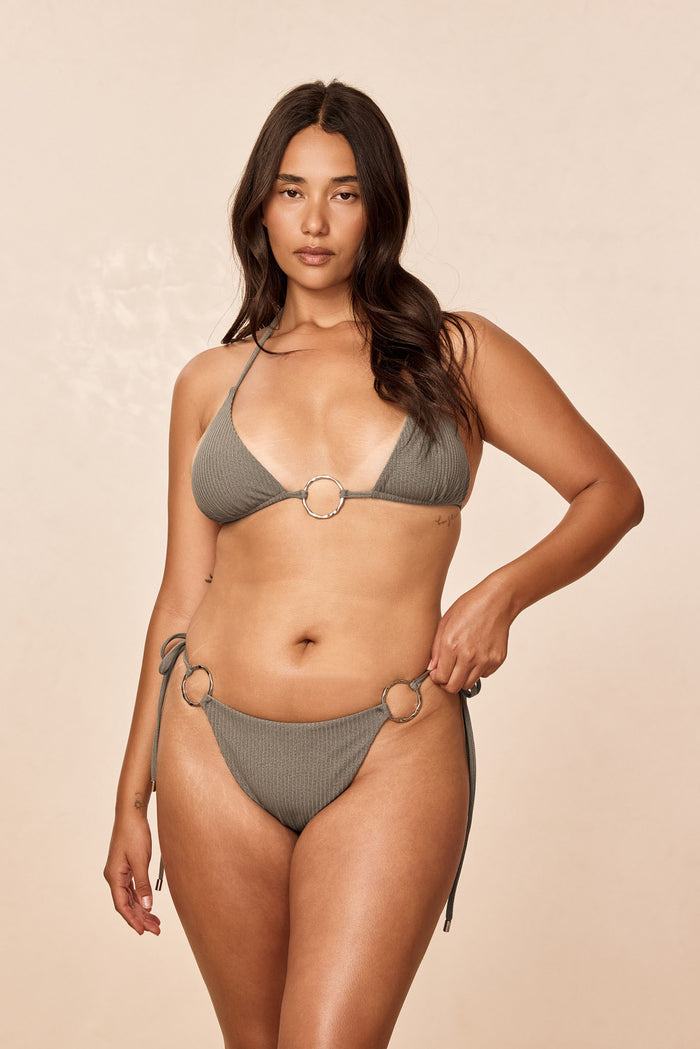 Front view of Cannes Bottom in Steel Lurex Rib showing ribbed lurex fabric and tie-side metal ring details on a beige background
